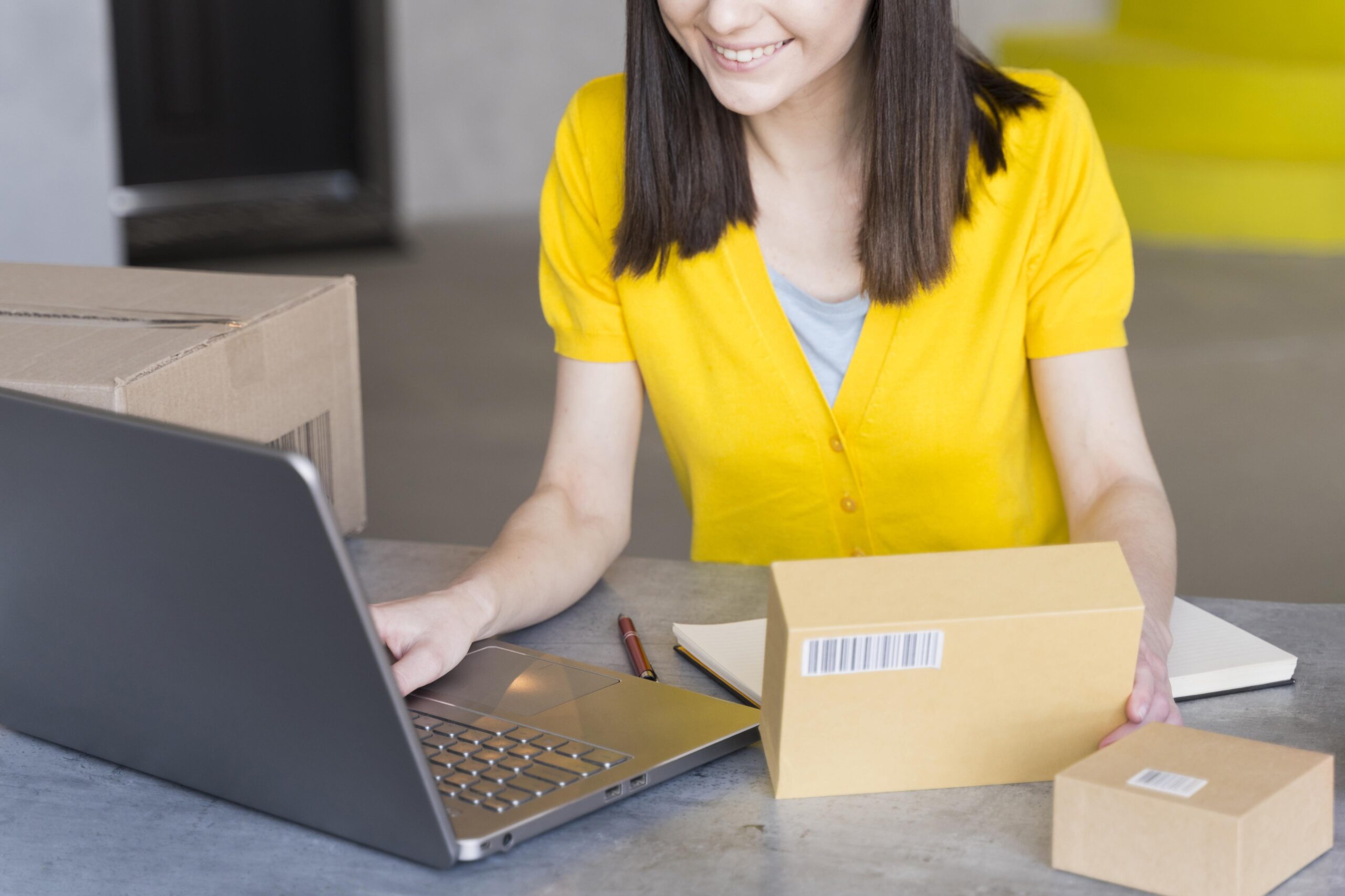 high-angle-woman-with-boxes-laptop
