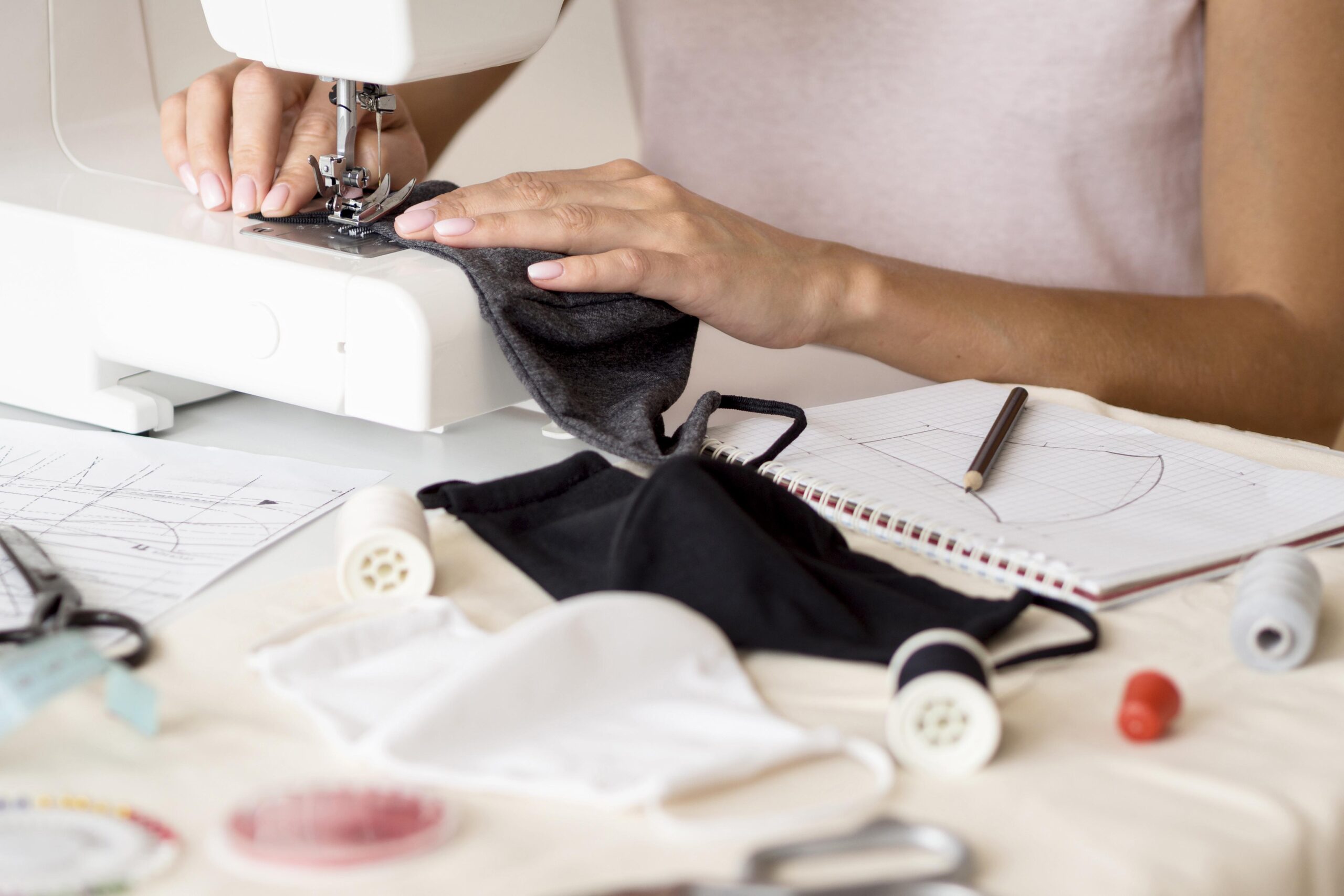 woman-sewing-face-mask-with-notebook