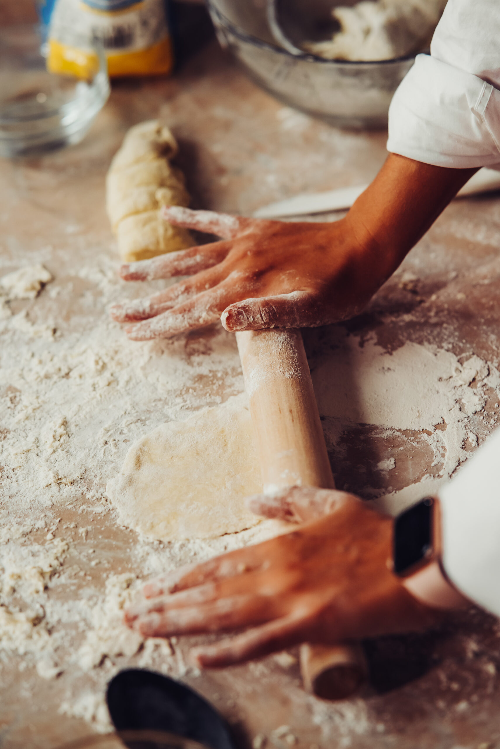 Close-up of young woman rolling dough with rolling pin